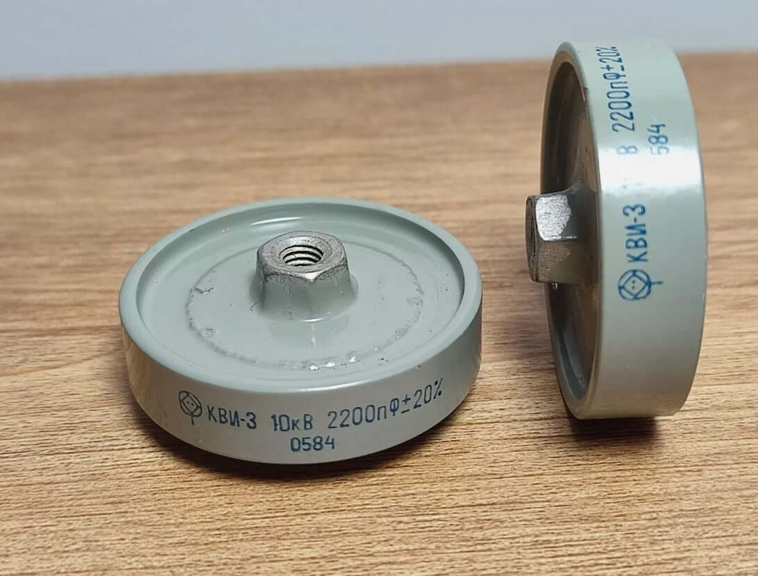 High voltage capacitors KBI-3 series with clear plastic casing and metallic connection for electronic applications.