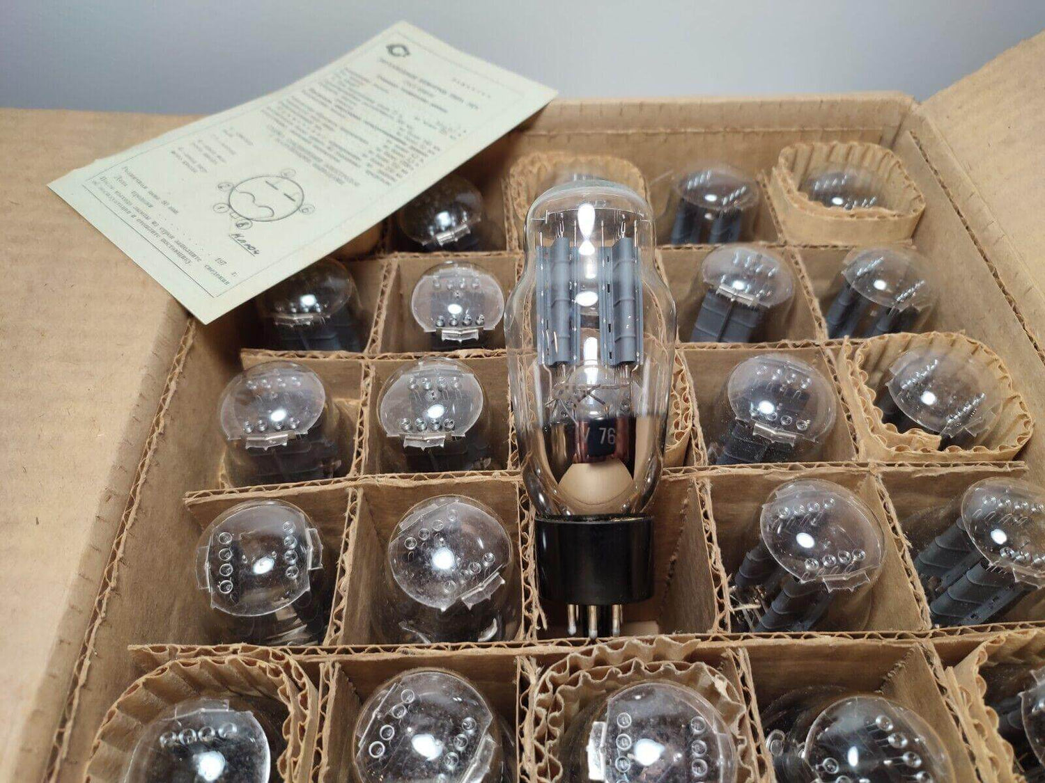 Collection of Soviet vacuum tubes in a box, featuring a clear vacuum tube and assembly instructions.