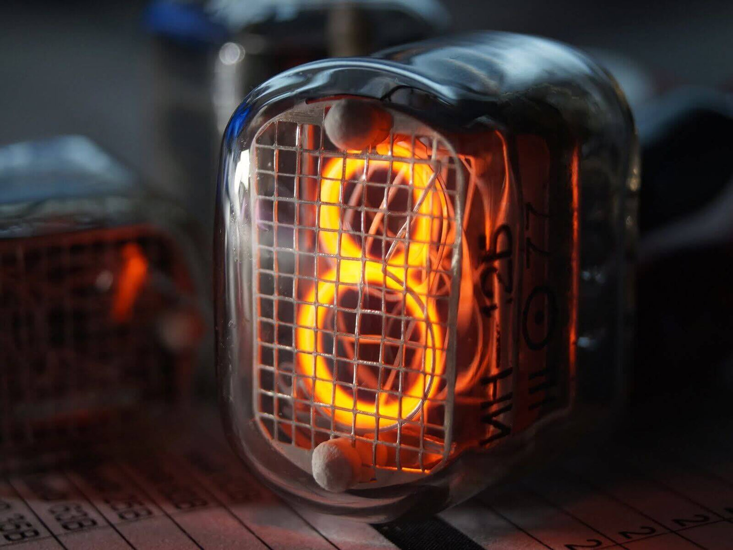 Close-up of a glowing NIXIE tube displaying the number 8, showcasing vintage electronics in detail.